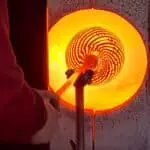 Glasposten mit fast fertiger Fadenglasvase wird im glory Hole, der Wärmetrommel von Ricardo durchgewärmt